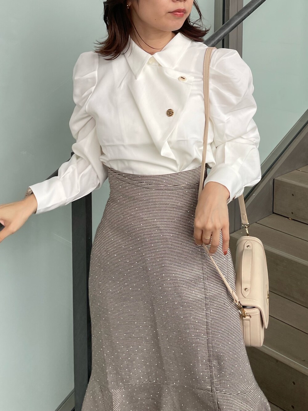 ホワイト系のシャツ/ブラウス、ブラウン系のスカート、ベージュ系のブーツを着用したレディースの秋コーディネートの4枚目の写真