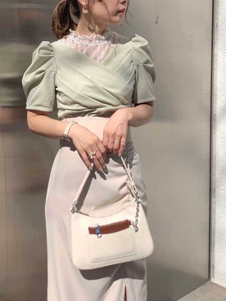 ベージュ系のスカート、グリーン系のTシャツ/カットソー、ホワイト系のサンダルを着用したレディースの春コーディネートの4枚目の写真