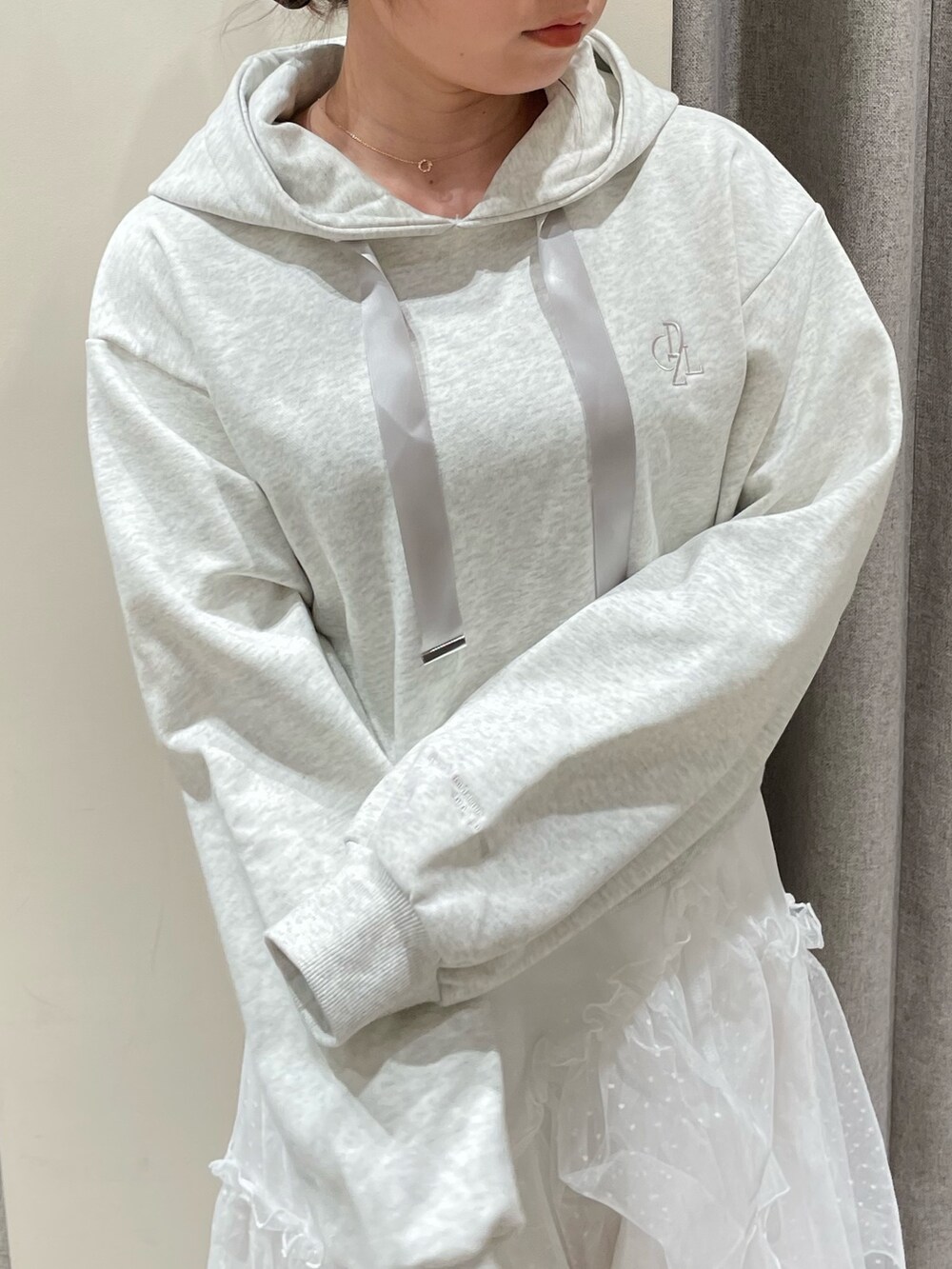 グレー系のパーカー、ホワイト系のスカート、ホワイト系のブーツを着用したレディースの春コーディネートの6枚目の写真