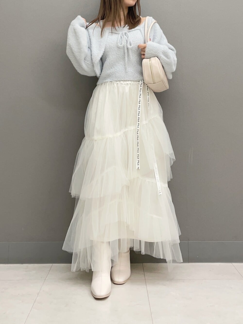 ホワイト系のハンドバッグ、ホワイト系のブーツ、グレー系のキャミソールを着用したレディースの秋コーディネートの7枚目の写真