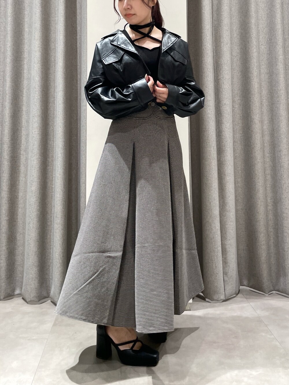 ブラック系のワンピース、ブラック系のパンプス、ブラック系のライダースジャケットを着用したレディースの秋コーディネートの2枚目の写真