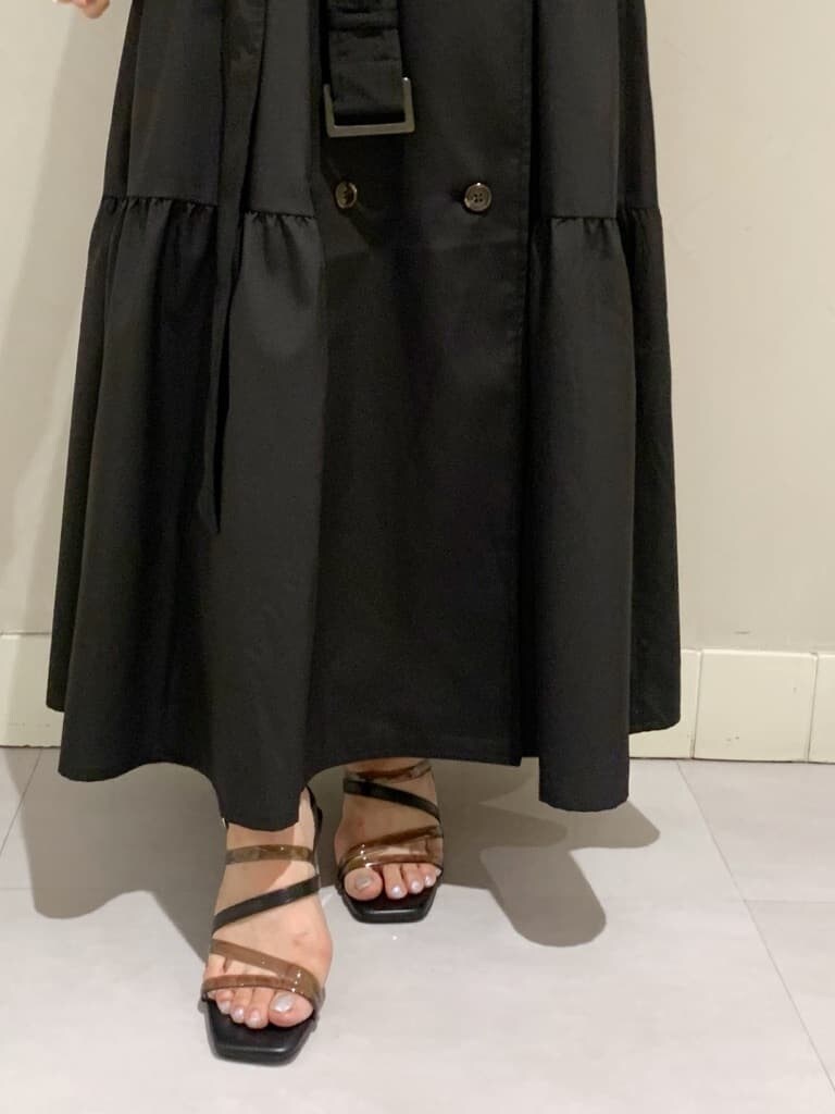 ブルー系のハンドバッグ、ブラック系のワンピース、ブラック系のサンダルを着用したレディースの春コーディネートの6枚目の写真