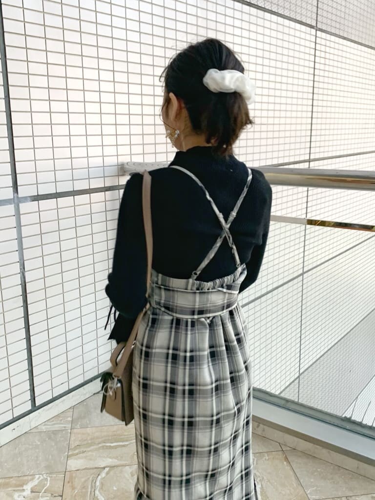 ブラック系のブーツ、グレー系のジャンパースカート、ブラック系のニット/セーターを着用したレディースの冬コーディネートの6枚目の写真