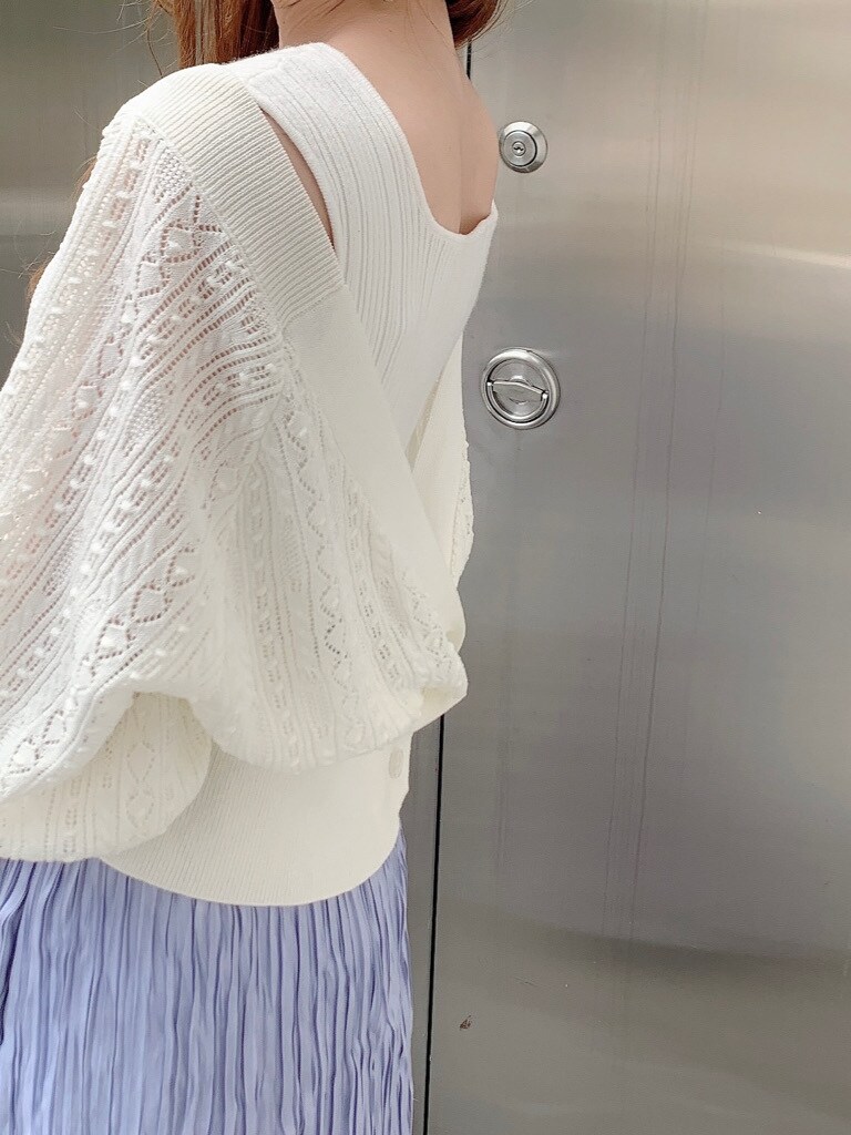 パープル系のスカート、ホワイト系のタンクトップ、ホワイト系のカーディガン/ボレロを着用したレディースの春コーディネートの3枚目の写真