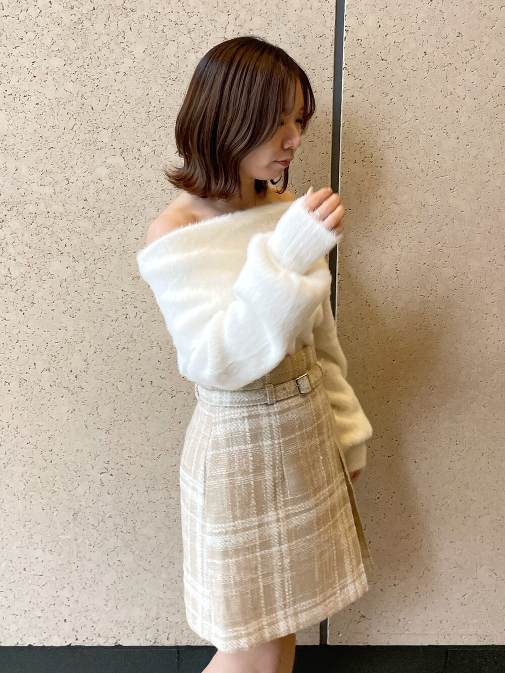 ホワイト系のニット/セーター、ベージュ系のスカート、ベージュ系のブーツを着用したレディースの秋コーディネートの5枚目の写真