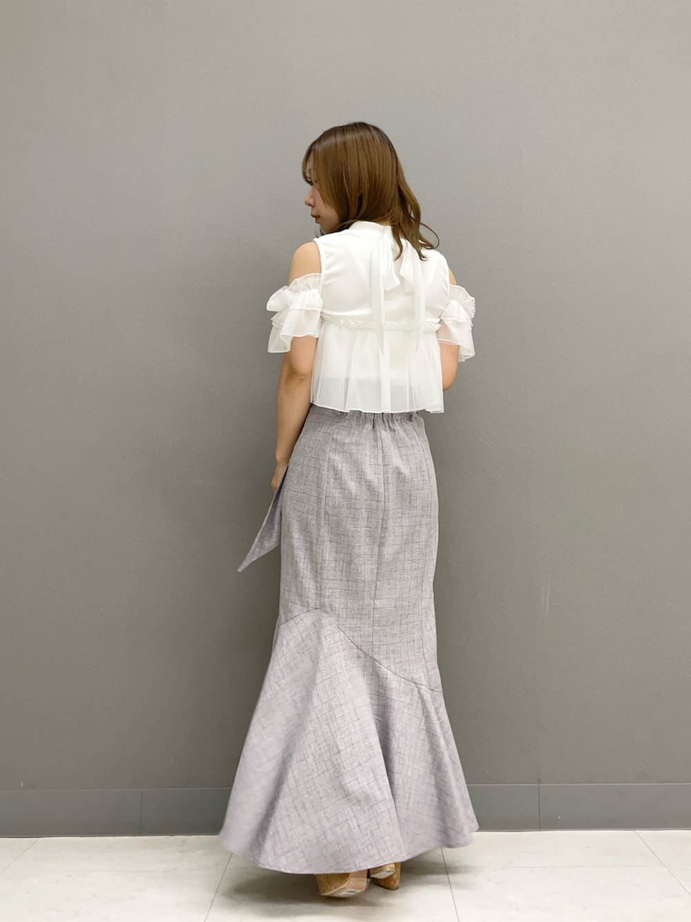 ホワイト系のTシャツ/カットソー、グレー系のスカート、ホワイト系のサンダルを着用したレディースの夏コーディネートの5枚目の写真