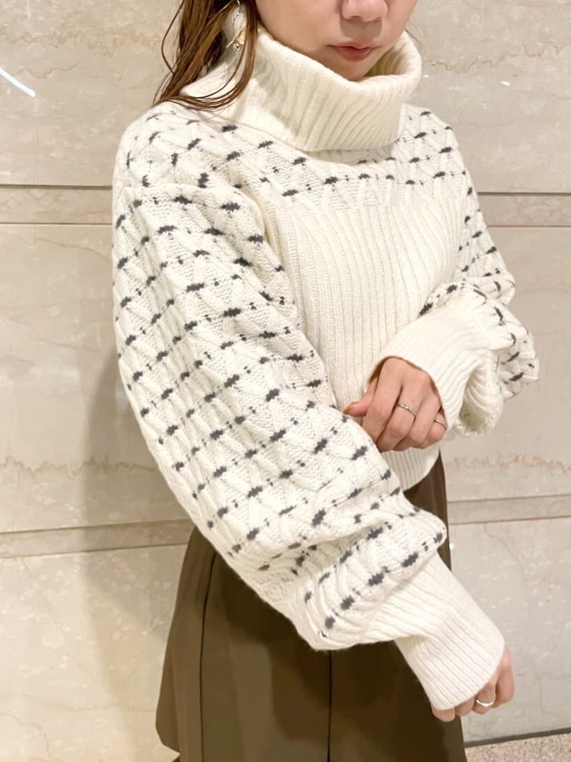 ブラウン系のスカート、ベージュ系のブーツ、ホワイト系のニット/セーターを着用したレディースの秋コーディネートの5枚目の写真