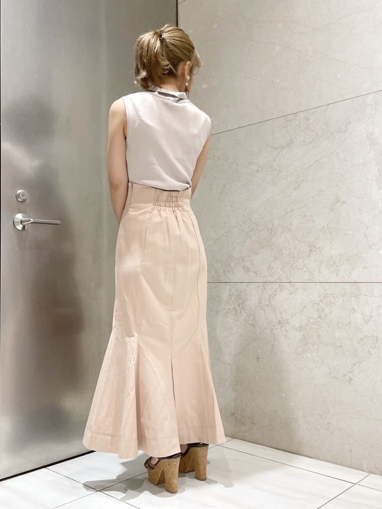 ブラウン系のサンダル、ピンク系のスカート、ブラウン系のハンドバッグを着用したレディースの夏コーディネートの4枚目の写真