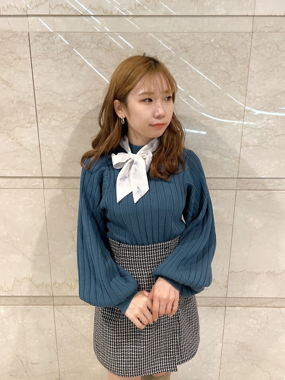 ブルー系のニット/セーター、ブラウン系のブーツ、ブルー系のスカートを着用したレディースの冬コーディネートの6枚目の写真