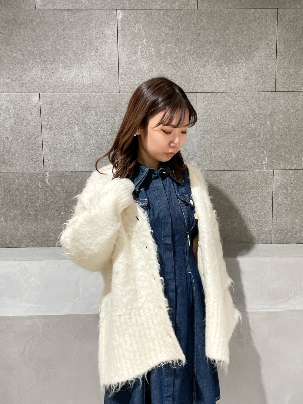 ホワイト系のカーディガン/ボレロ、ブルー系のシャツワンピース、ホワイト系のブーツを着用したレディースの冬コーディネートの5枚目の写真