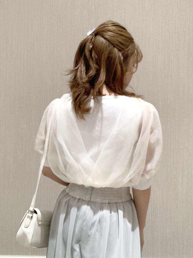 ホワイト系のニット/セーター、ホワイト系のショルダーバッグ、グレー系のスカートを着用したレディースの春コーディネートの7枚目の写真