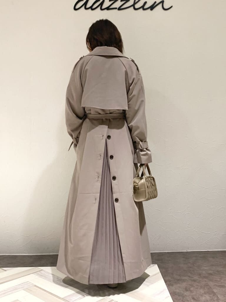 ブラウン系のワンピース、グレー系のトレンチコート、ベージュ系のハンドバッグを着用したレディースの秋コーディネートの9枚目の写真