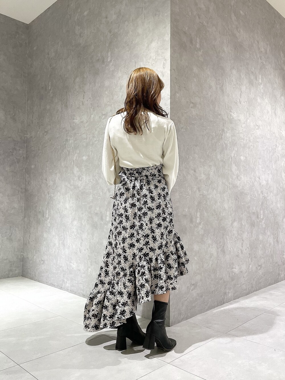 ホワイト系のニット/セーター、その他のスカート、ブラック系のブーツを着用したレディースの秋コーディネートの3枚目の写真