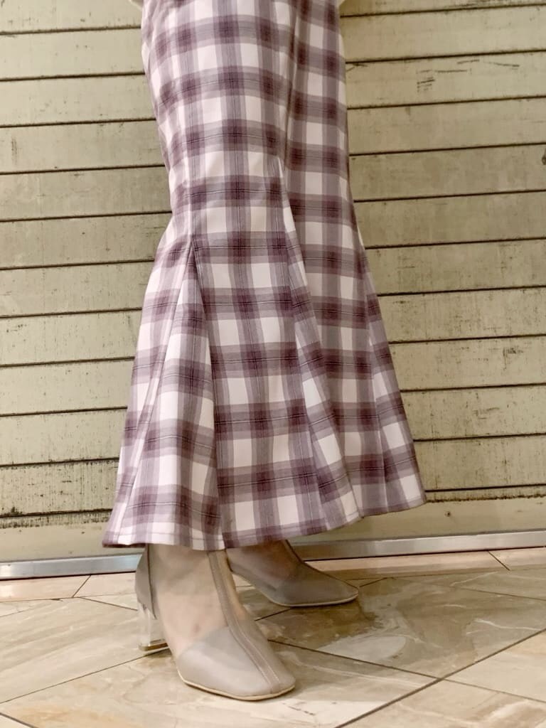 ホワイト系のパーカー、ベージュ系のブーツ、パープル系のスカートを着用したレディースの冬コーディネートの8枚目の写真