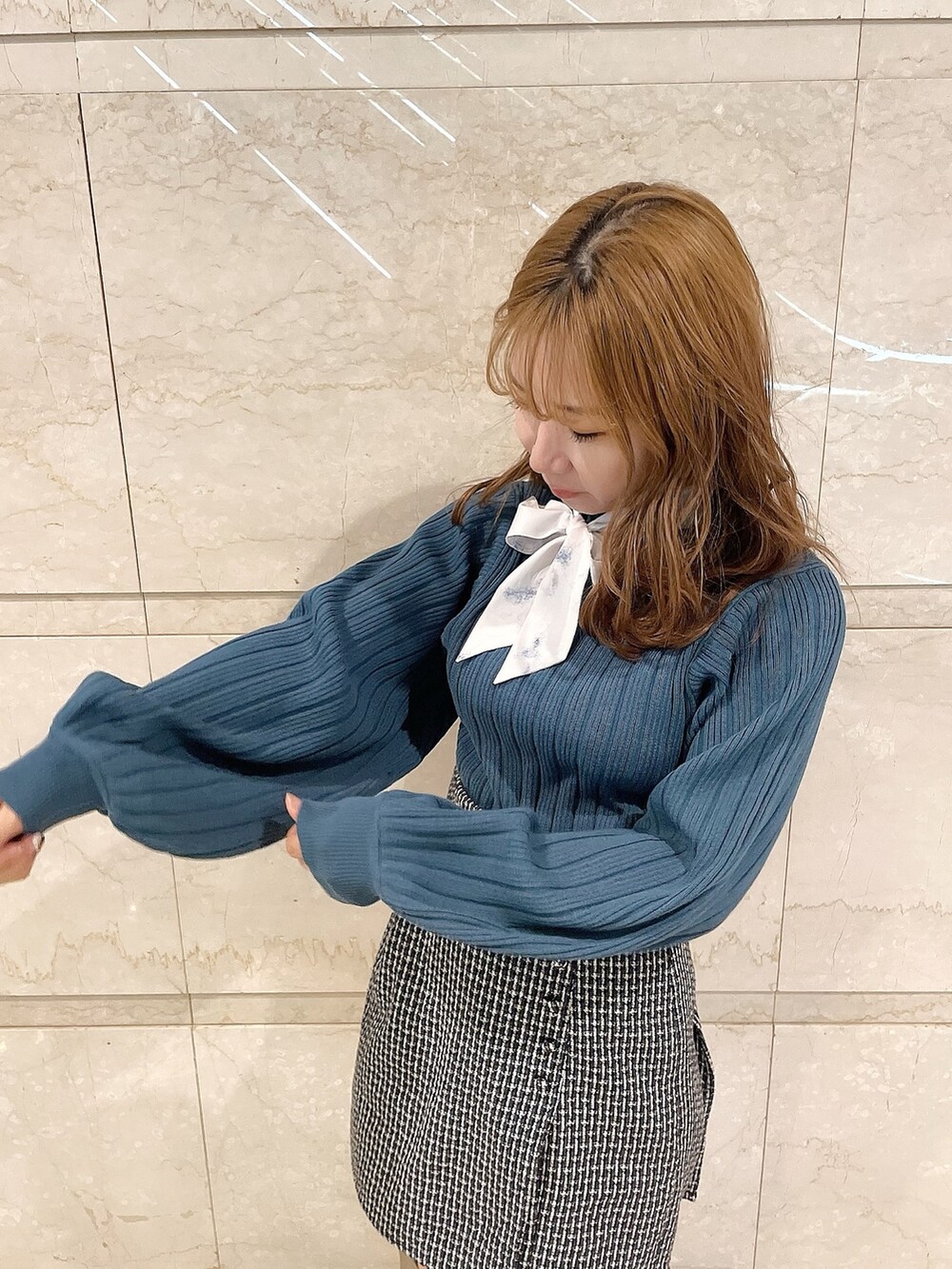 ブルー系のニット/セーター、ブラウン系のブーツ、ブルー系のスカートを着用したレディースの冬コーディネートの8枚目の写真