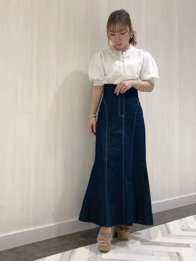 ブルー系のスカート、ホワイト系のニット/セーター、ベージュ系のサンダルを着用したレディースの春コーディネートの4枚目の写真