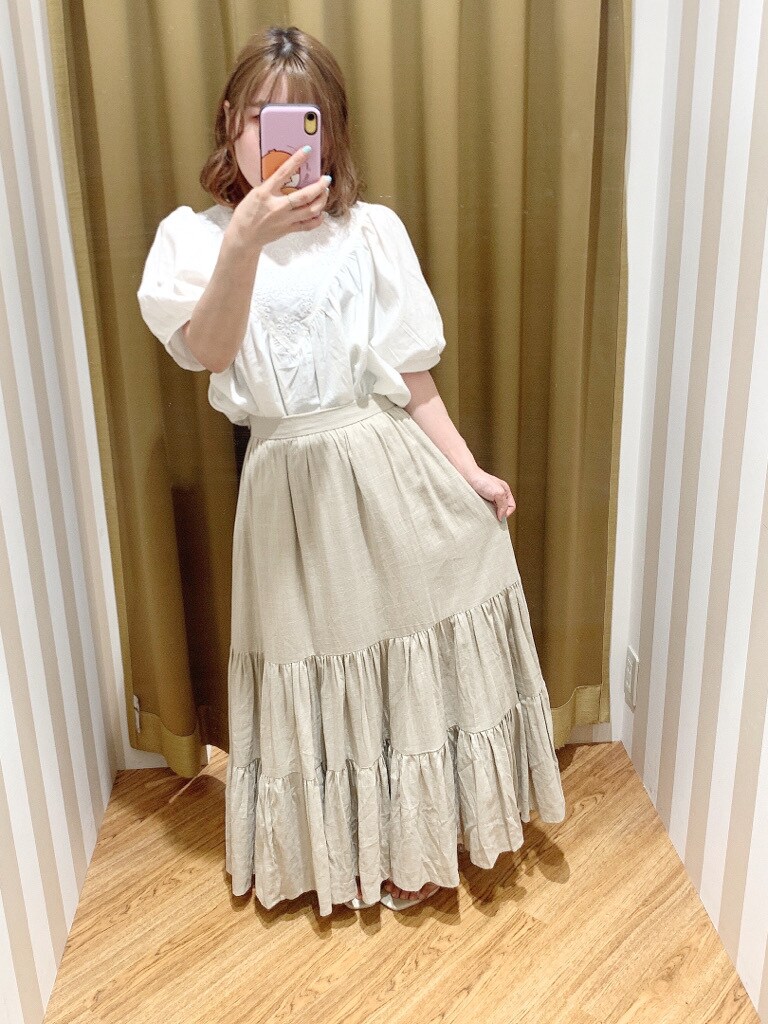 ホワイト系のシャツ/ブラウス、ベージュ系のスカート、その他のサンダルを着用したレディースの春コーディネートの2枚目の写真