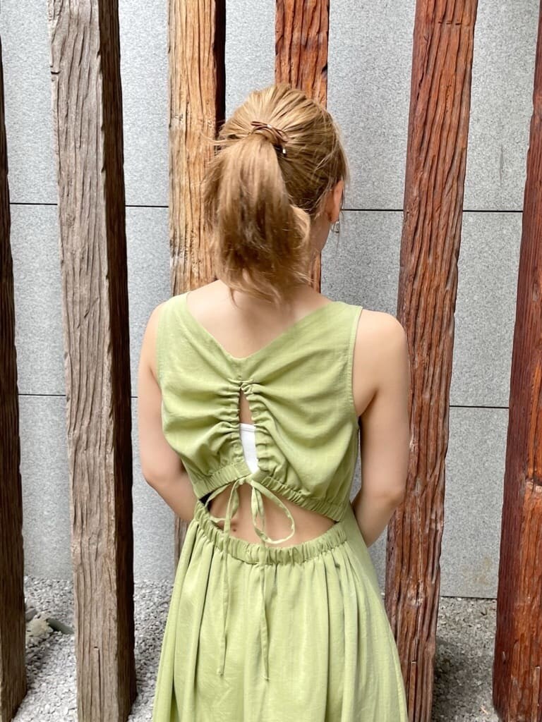 パープル系のサンダル、グリーン系のワンピース、シルバー系のピアス（両耳用）を着用したレディースの夏コーディネートの7枚目の写真