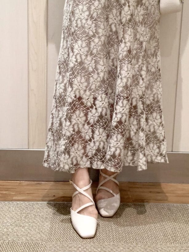 ベージュ系のスカート、ホワイト系のパンプス、グリーン系のニット/セーターを着用したレディースの春コーディネートの7枚目の写真