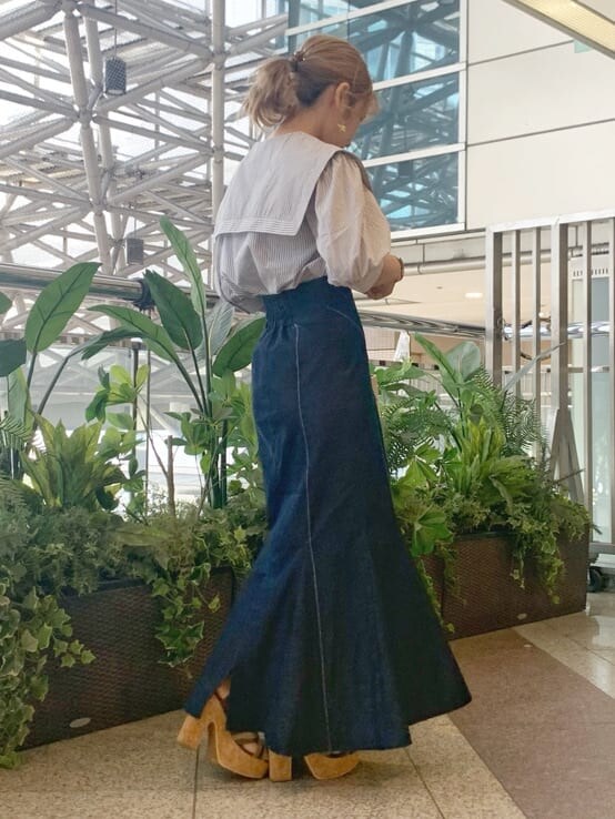 グレー系のシャツ/ブラウス、ベージュ系のハンドバッグ、ブラウン系のサンダルを着用したレディースの春コーディネートの3枚目の写真