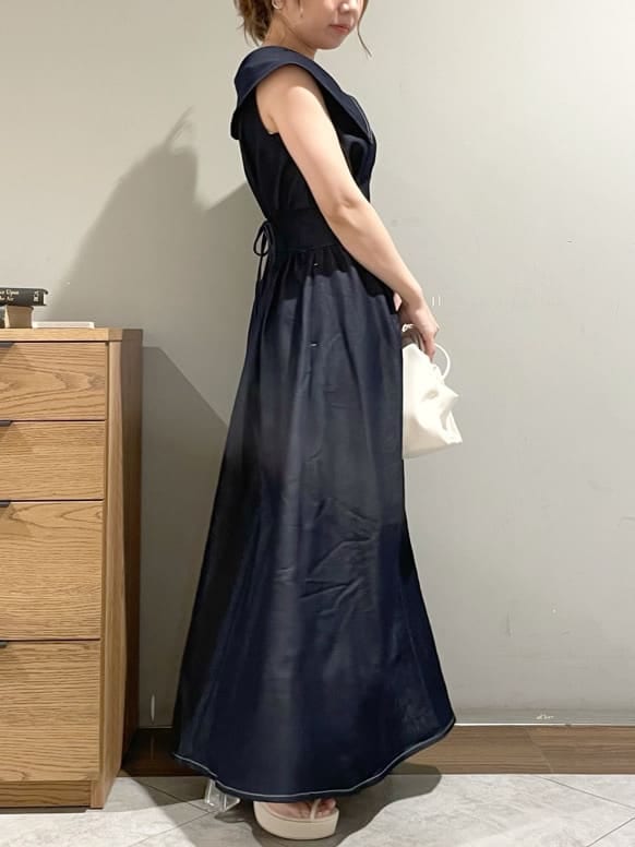 ホワイト系のハンドバッグ、ホワイト系のサンダル、ブルー系のワンピースを着用したレディースの夏コーディネートの3枚目の写真