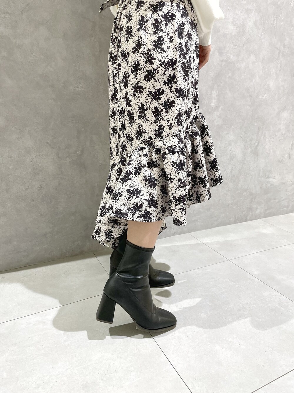 ホワイト系のニット/セーター、その他のスカート、ブラック系のブーツを着用したレディースの秋コーディネートの9枚目の写真