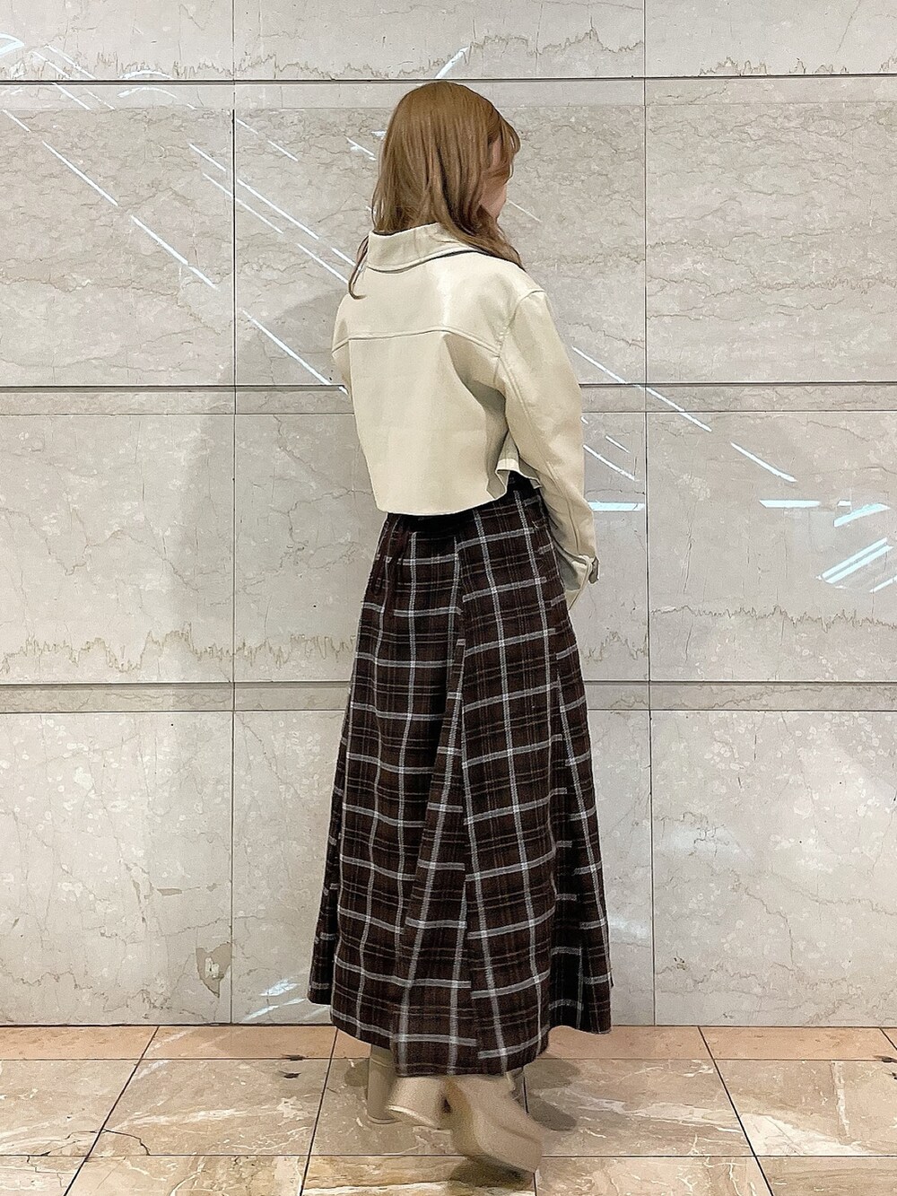 ホワイト系のライダースジャケット、ピンク系のシャツ/ブラウス、ブラウン系のスカートを着用したレディースの冬コーディネートの3枚目の写真