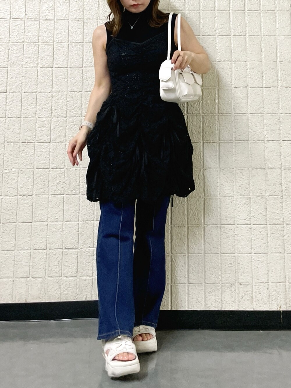 ブラック系のワンピース、ブラック系のニット/セーター、ホワイト系のボストンバッグを着用したレディースの春コーディネートの6枚目の写真