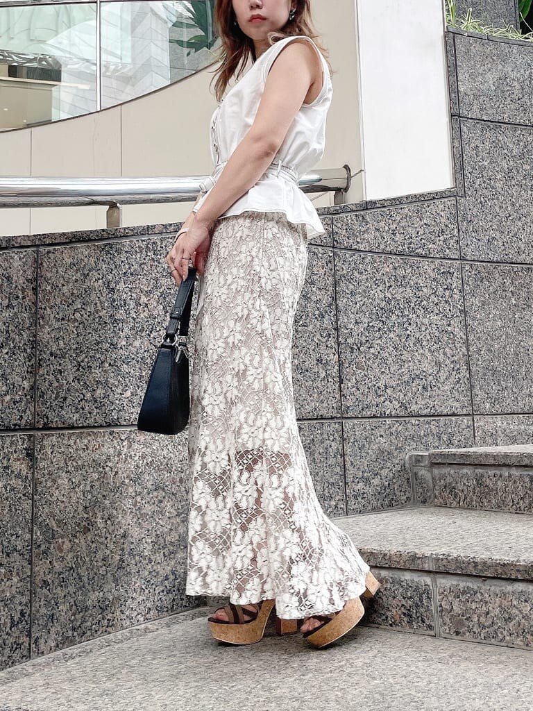 ベージュ系のスカート、ブラウン系のサンダル、ホワイト系のシャツ/ブラウスを着用したレディースの夏コーディネートの4枚目の写真