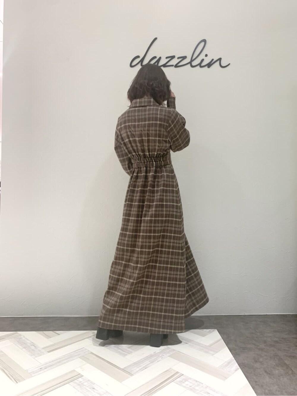 ブルー系のチェスターコート、ブラック系のブーツ、その他のワンピースを着用したレディースの秋コーディネートの4枚目の写真