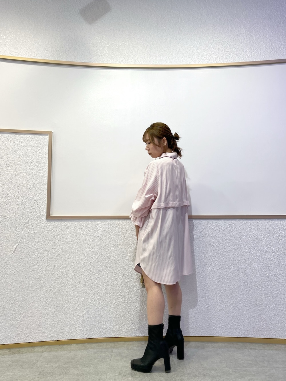 ピンク系のワンピース、ブラック系のブーツ、グレー系のスカートを着用したレディースの春コーディネートの5枚目の写真