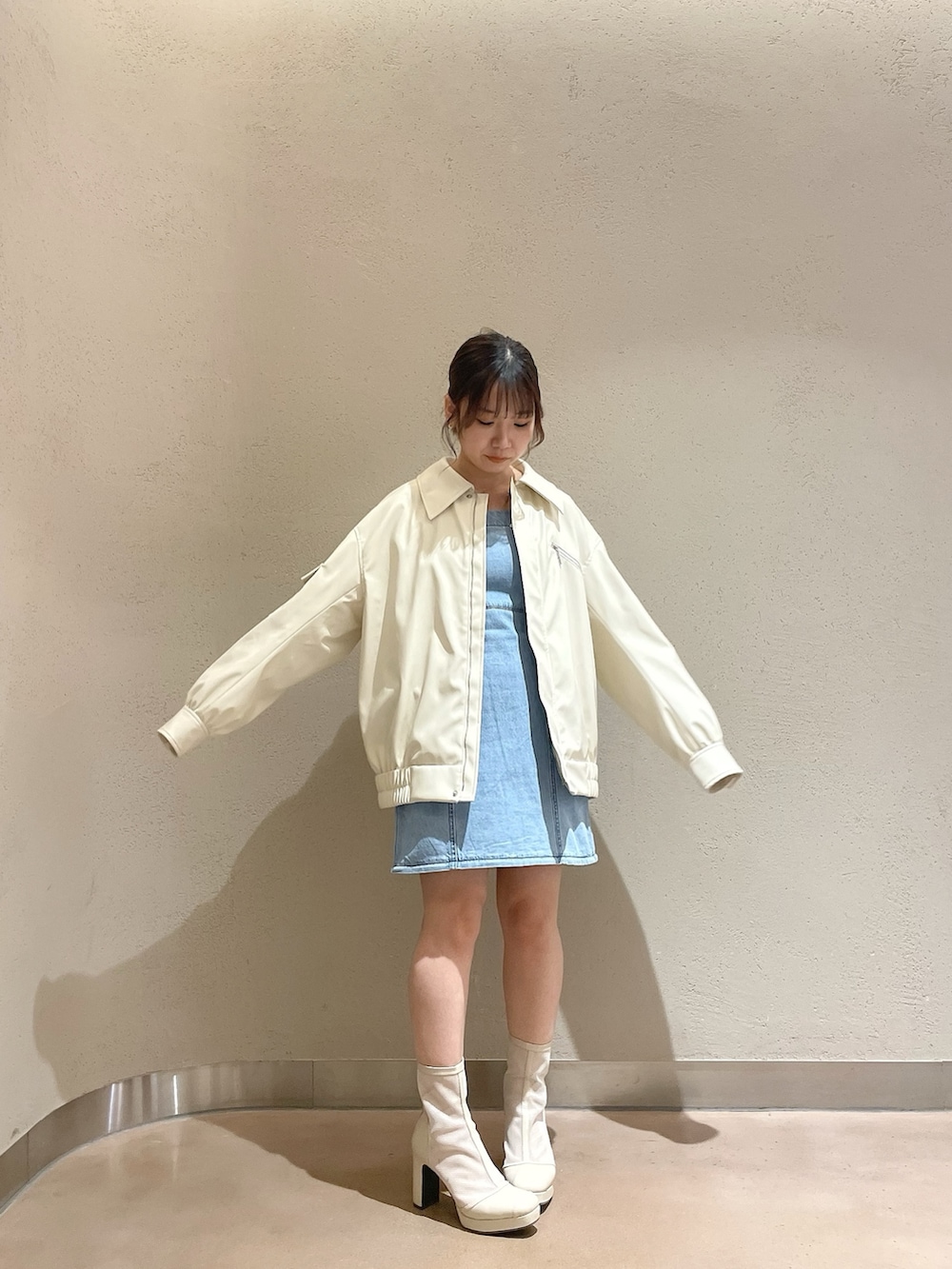 ホワイト系のブルゾン、ブルー系のワンピース、ホワイト系のブーツを着用したレディースの冬コーディネートの5枚目の写真