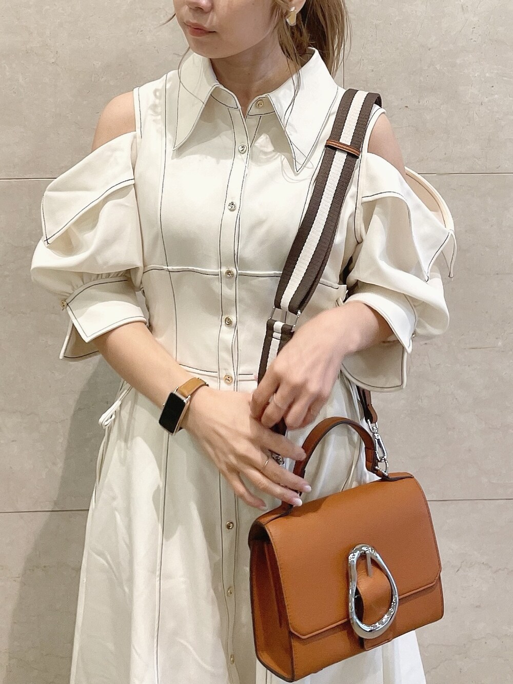 ホワイト系のワンピース、ホワイト系のパンプス、イエロー系のハンドバッグを着用したレディースの冬コーディネートの5枚目の写真