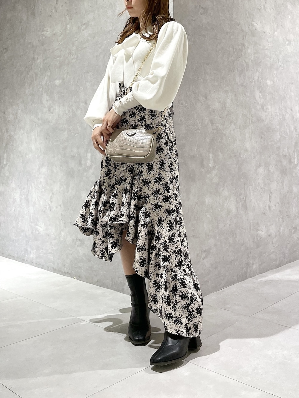 ホワイト系のニット/セーター、その他のスカート、ブラック系のブーツを着用したレディースの秋コーディネートの2枚目の写真