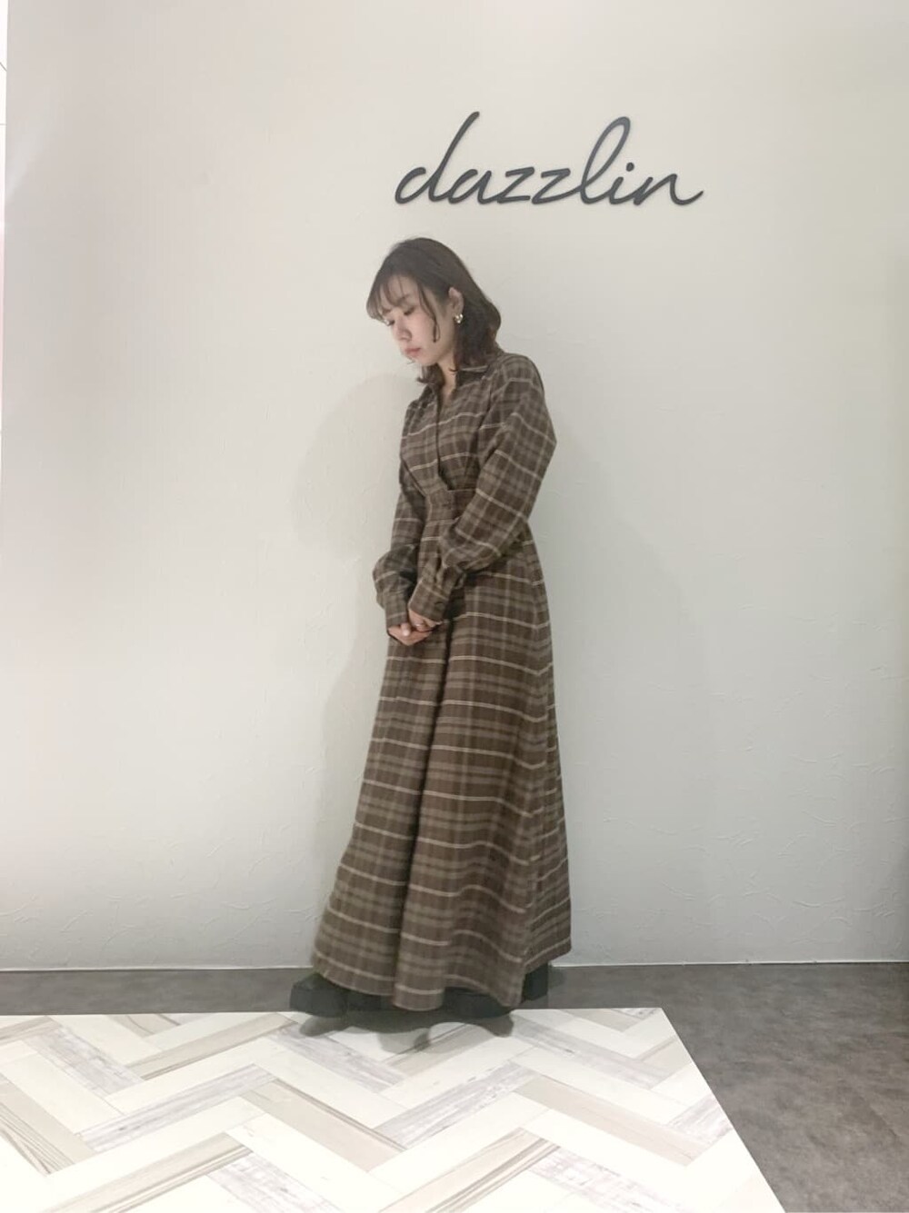 ブルー系のチェスターコート、ブラック系のブーツ、その他のワンピースを着用したレディースの秋コーディネートの3枚目の写真