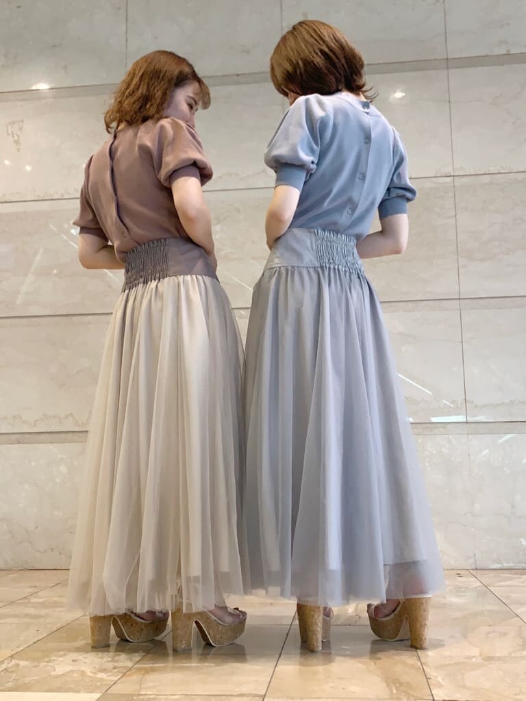 グレー系のスカート、ベージュ系のスカート、その他のサンダルを着用したレディースの夏コーディネートの2枚目の写真