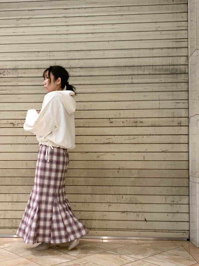 ホワイト系のパーカー、ベージュ系のブーツ、パープル系のスカートを着用したレディースの冬コーディネートの5枚目の写真