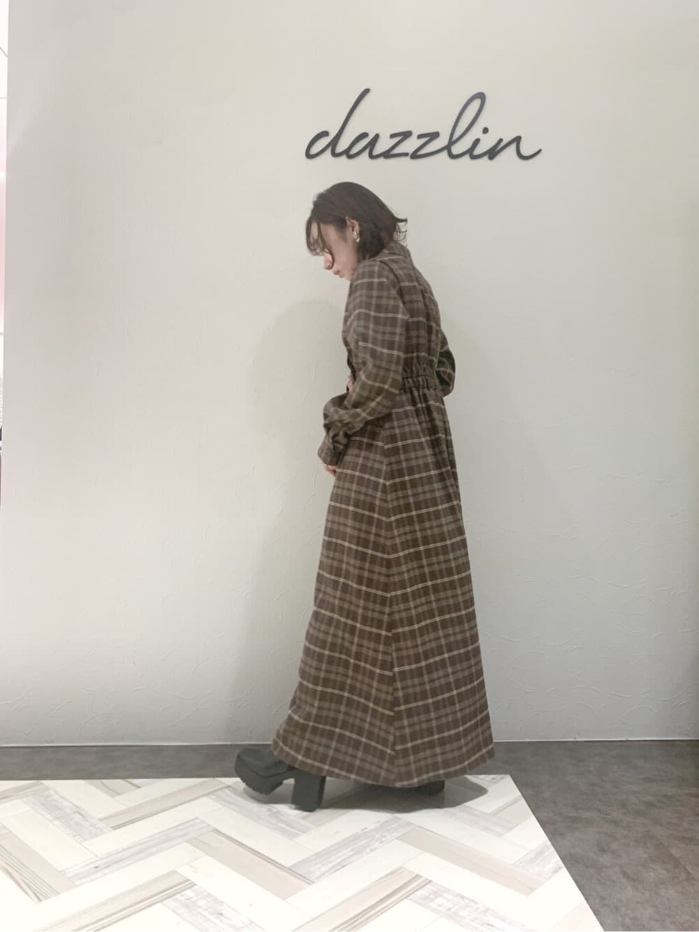 ブルー系のチェスターコート、ブラック系のブーツ、その他のワンピースを着用したレディースの秋コーディネートの5枚目の写真