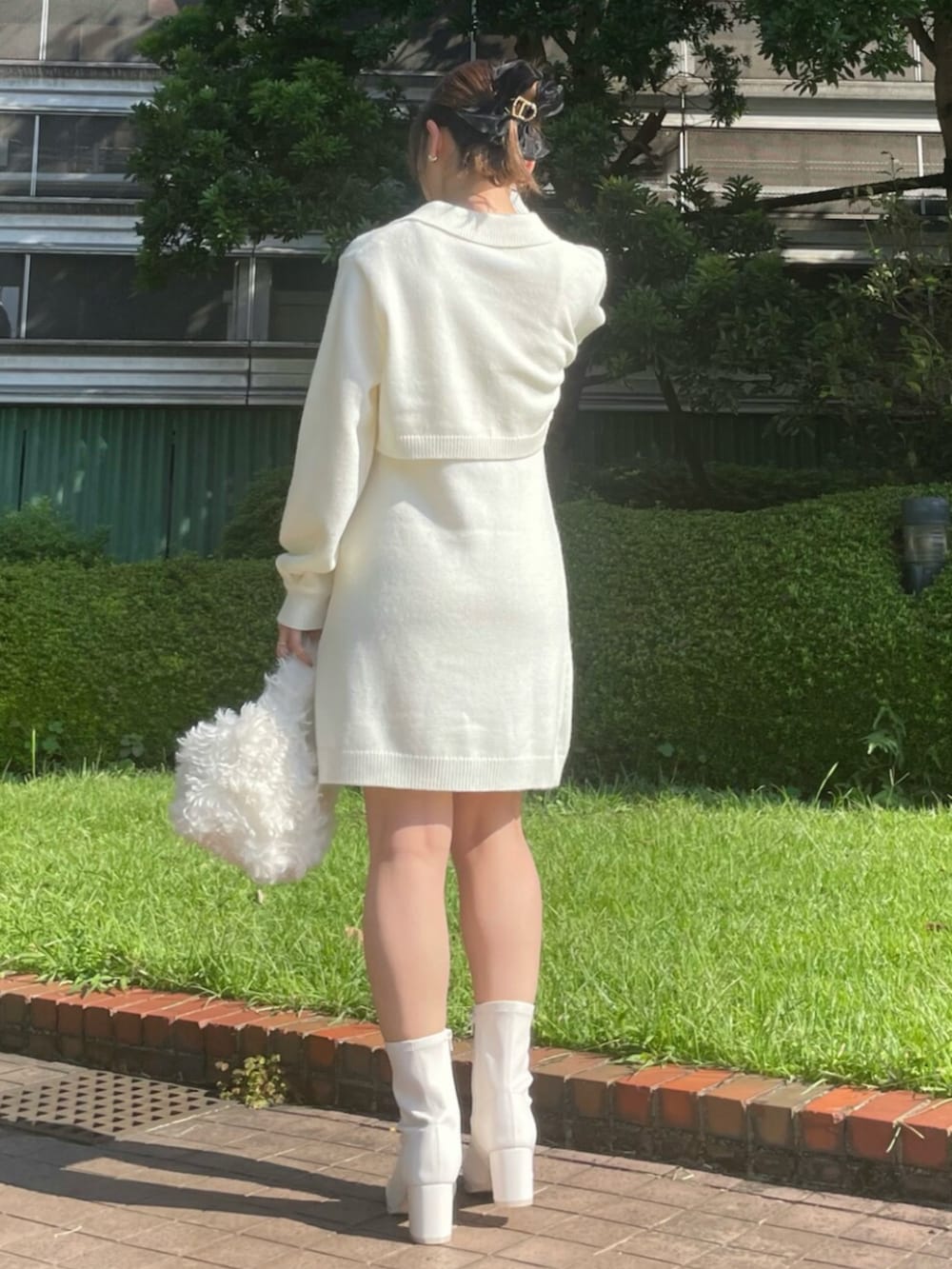 ホワイト系のハンドバッグ、ホワイト系のブーツ、ホワイト系のワンピースを着用したレディースの秋コーディネートの3枚目の写真