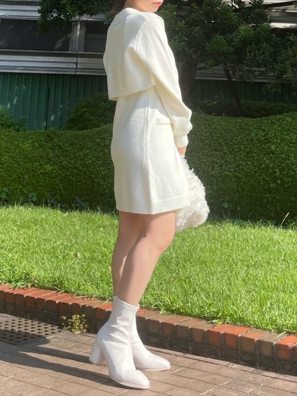 ホワイト系のハンドバッグ、ホワイト系のブーツ、ホワイト系のワンピースを着用したレディースの秋コーディネートの2枚目の写真