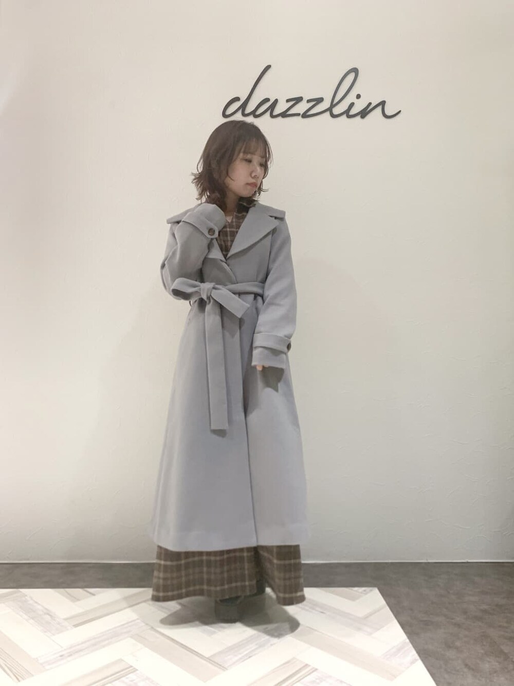 ブルー系のチェスターコート、ブラック系のブーツ、その他のワンピースを着用したレディースの秋コーディネートの7枚目の写真