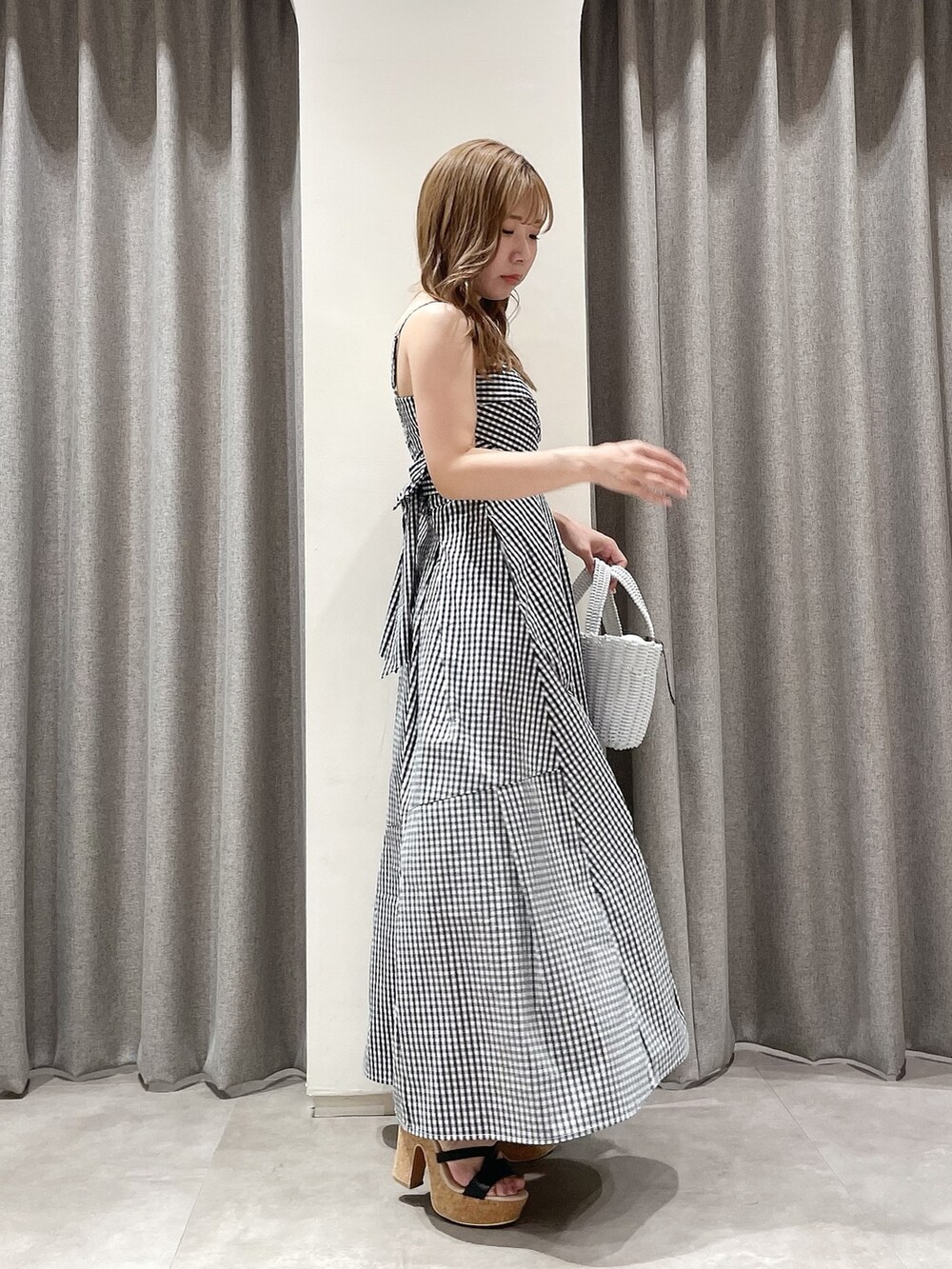 その他のワンピース、ホワイト系のハンドバッグ、ブラック系のサンダルを着用したレディースの夏コーディネートの2枚目の写真