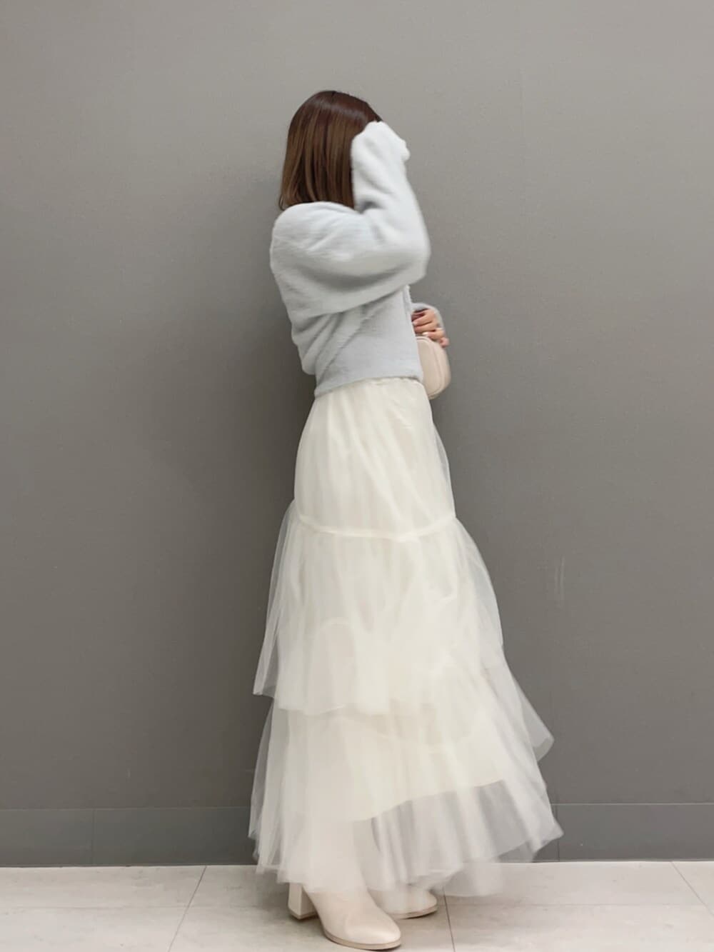 ホワイト系のハンドバッグ、ホワイト系のブーツ、グレー系のキャミソールを着用したレディースの秋コーディネートの6枚目の写真