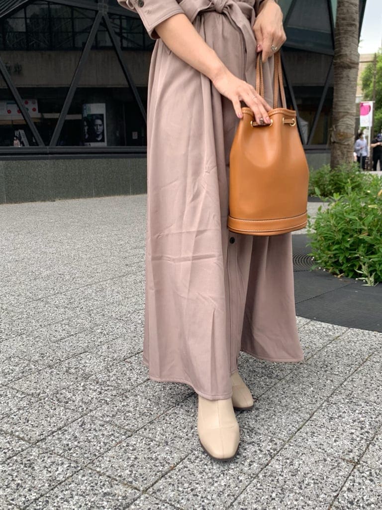 ベージュ系のワンピース、ブラウン系のバックパック/リュック、ベージュ系のブーツを着用したレディースの夏コーディネートの7枚目の写真