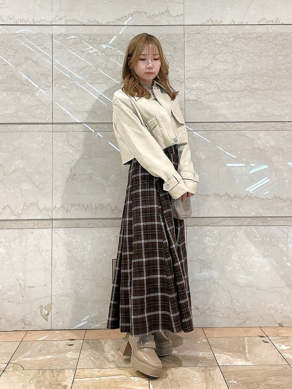 ホワイト系のライダースジャケット、ピンク系のシャツ/ブラウス、ブラウン系のスカートを着用したレディースの冬コーディネートの5枚目の写真