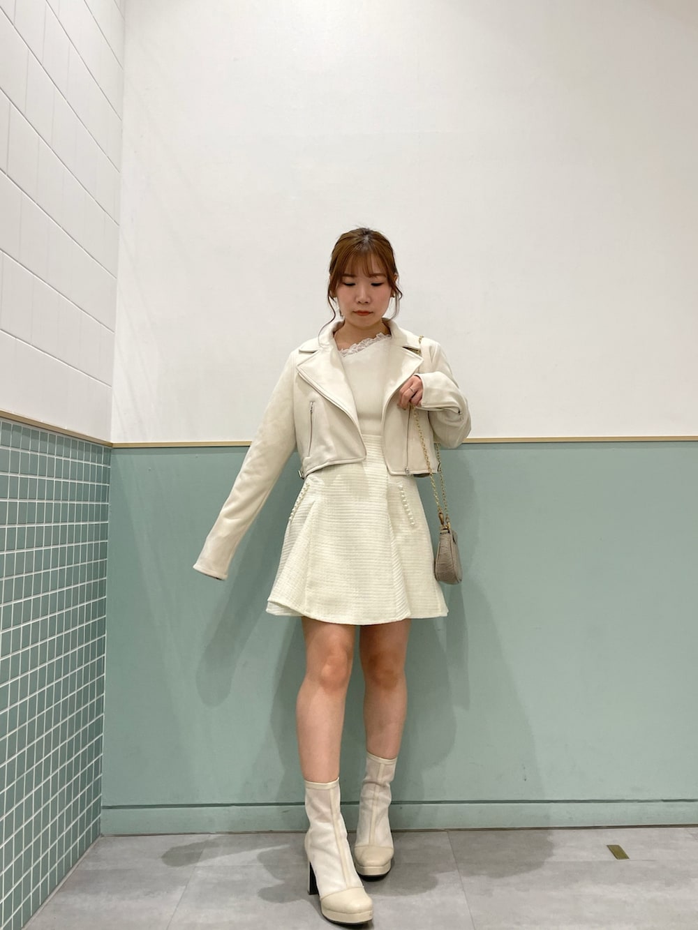 ホワイト系のライダースジャケット、ホワイト系のニット/セーター、ホワイト系のスカートを着用したレディースの春コーディネートの3枚目の写真