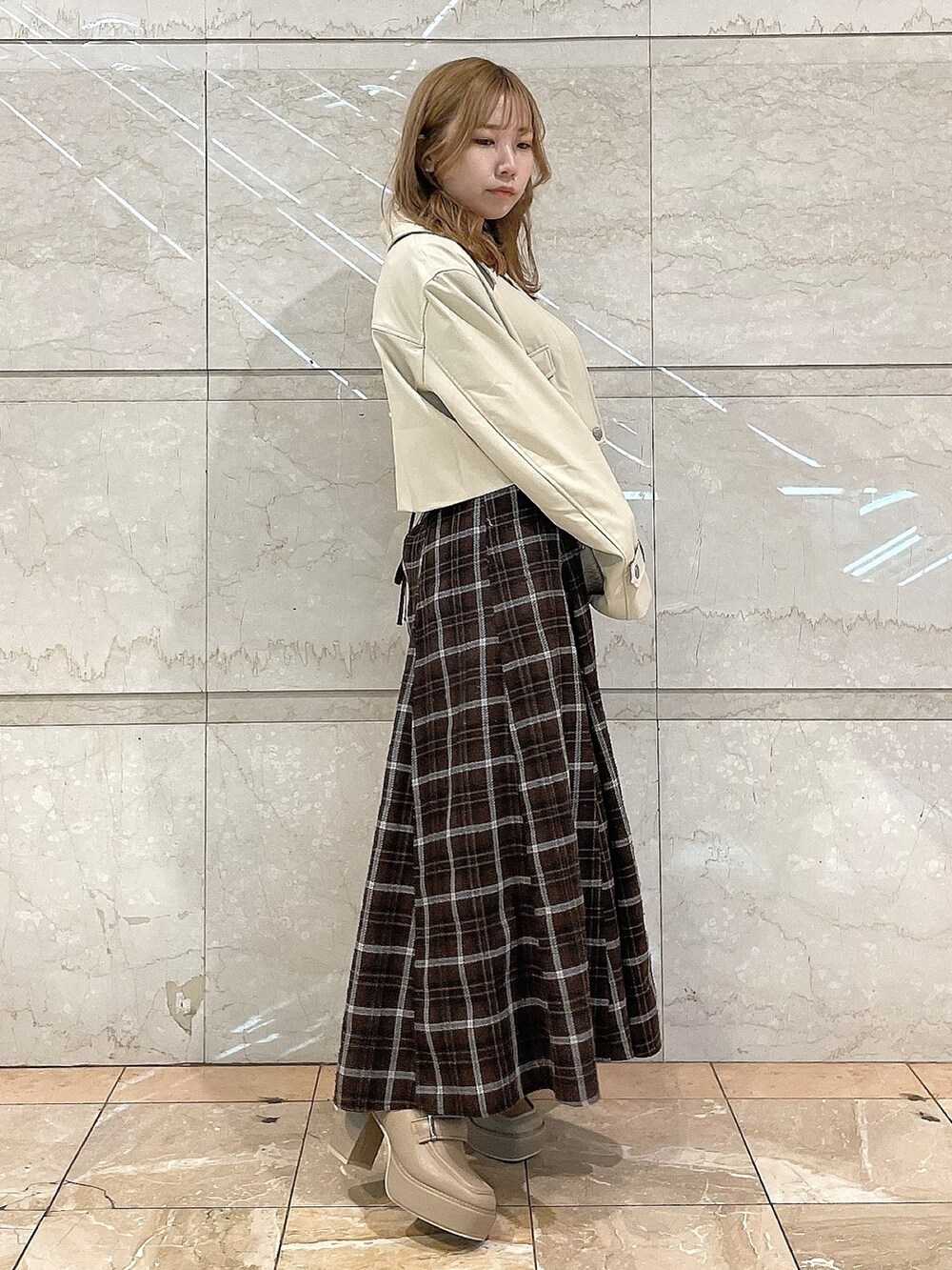 ホワイト系のライダースジャケット、ピンク系のシャツ/ブラウス、ブラウン系のスカートを着用したレディースの冬コーディネートの2枚目の写真