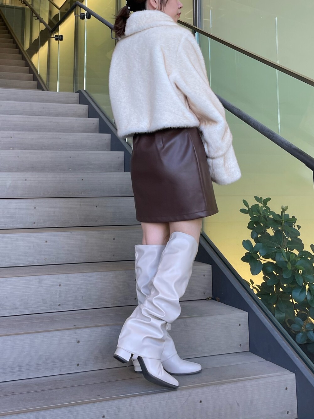 ホワイト系のその他アウター、ブラウン系のスカート、ベージュ系のブーツを着用したレディースの秋コーディネートの3枚目の写真