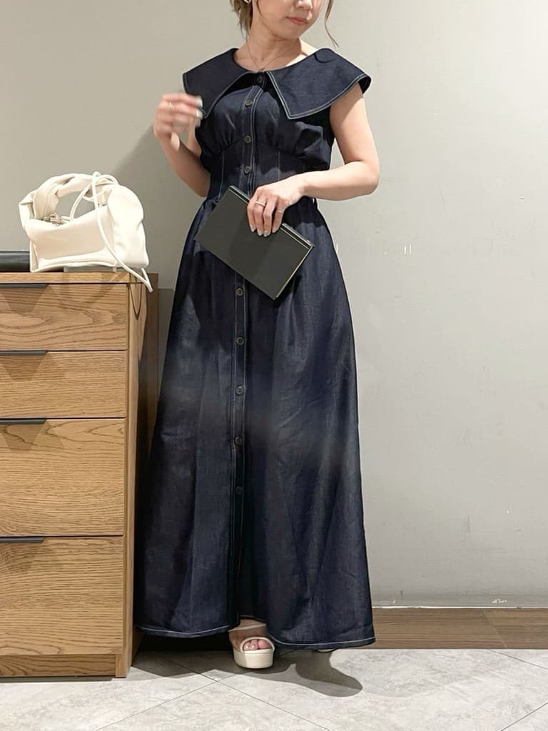 ホワイト系のハンドバッグ、ホワイト系のサンダル、ブルー系のワンピースを着用したレディースの夏コーディネートの4枚目の写真