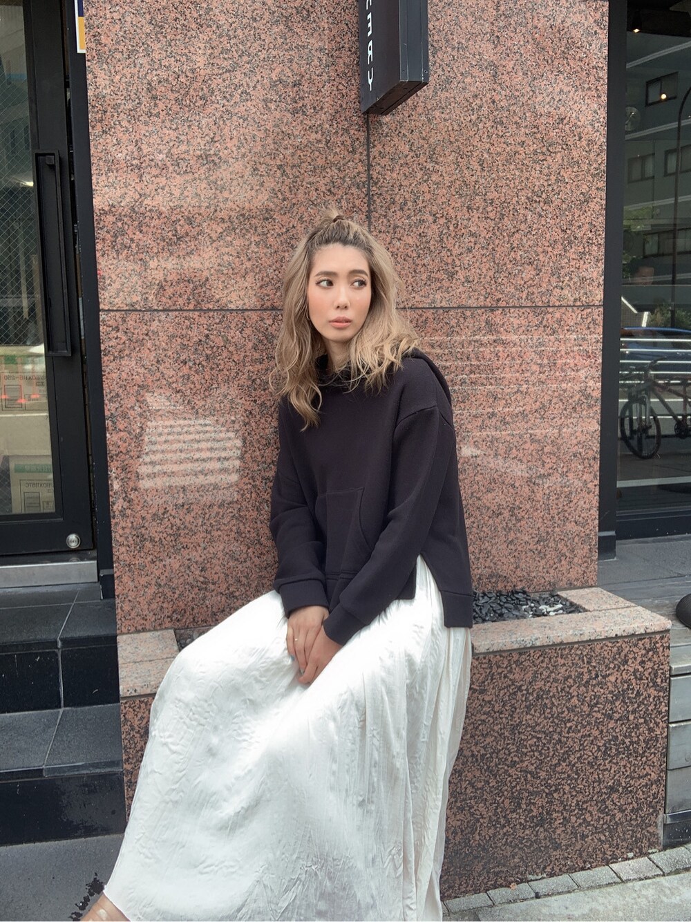 ホワイト系のスカート、ブラック系のパーカーを着用したレディースの夏コーディネートの4枚目の写真